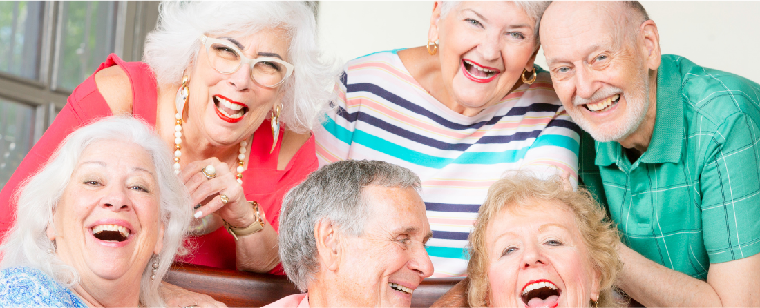 A joyful group of older adults laughing and singing together